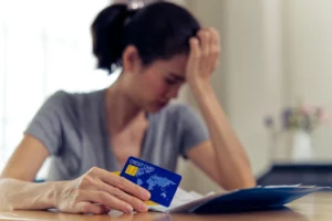 Stressed woman with credit card and bills showing Chapter 7 debt concerns in Chicago